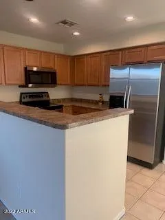 a kitchen with kitchen island a counter top space cabinets and stainless steel appliances