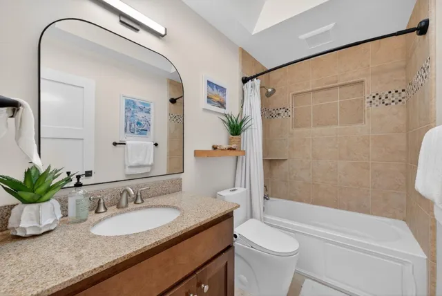 a bathroom with a granite countertop sink toilet and shower
