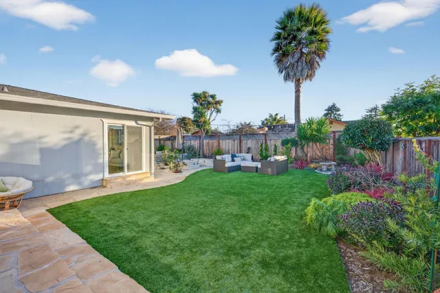 a view of an house with backyard and a garden