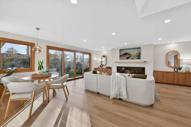 a living room with furniture a large window and a fireplace