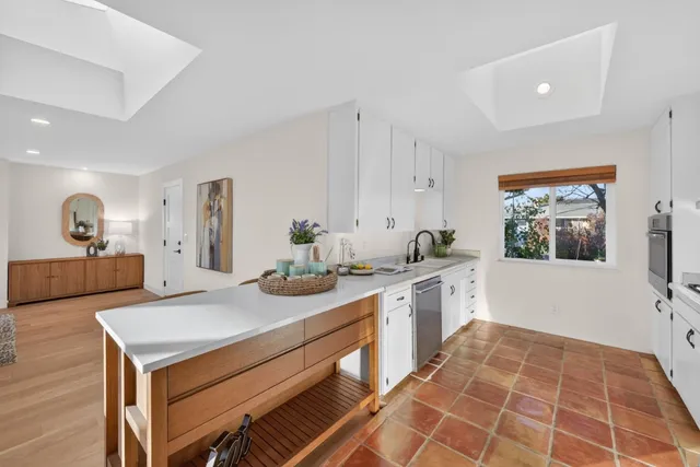 a large white kitchen with a stove a sink and a refrigerator
