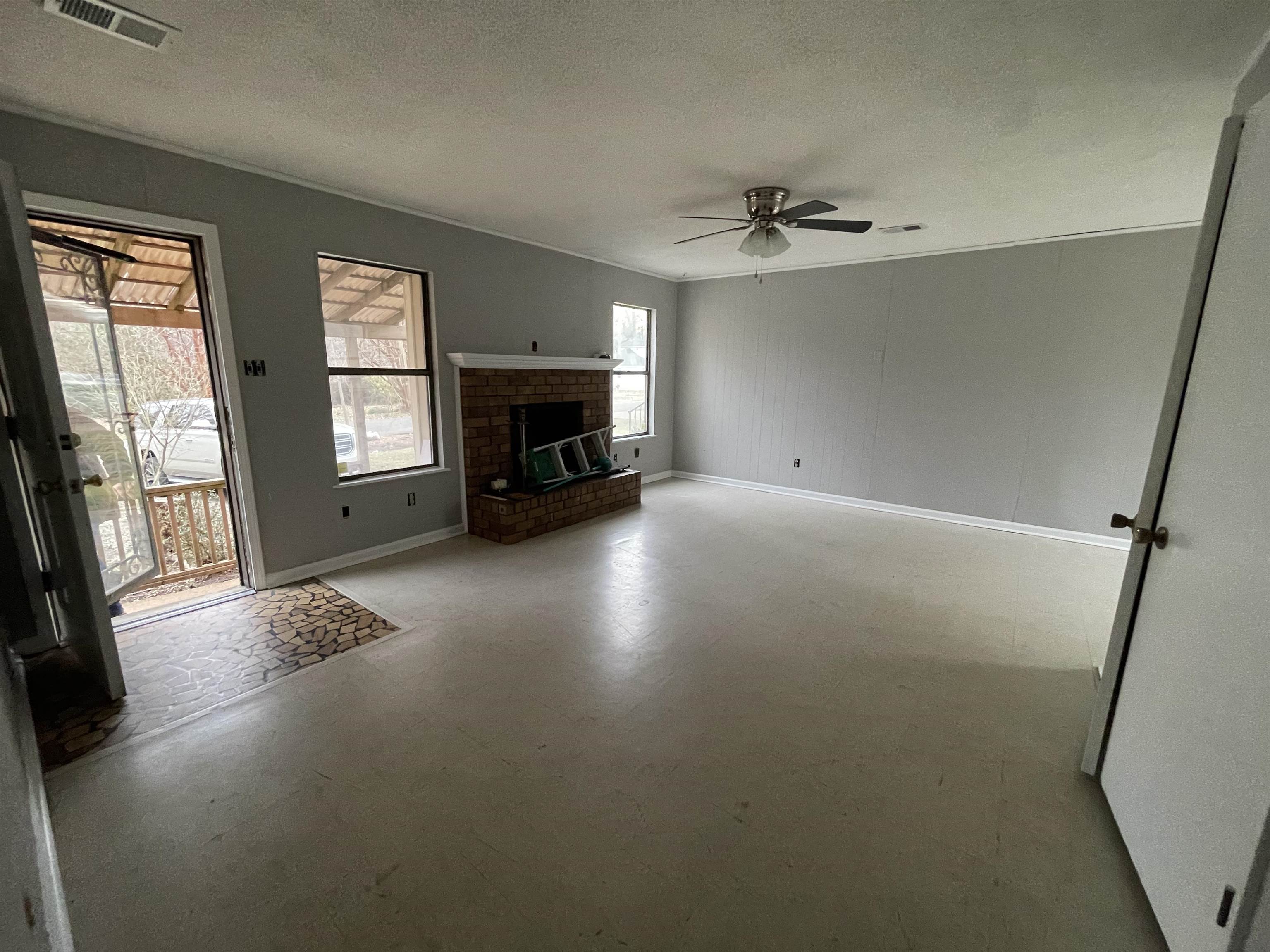 885 Echles Street Memphis, TN 38111 - Photo 12 of 18 wooden floor in an empty room with a fireplace and a window