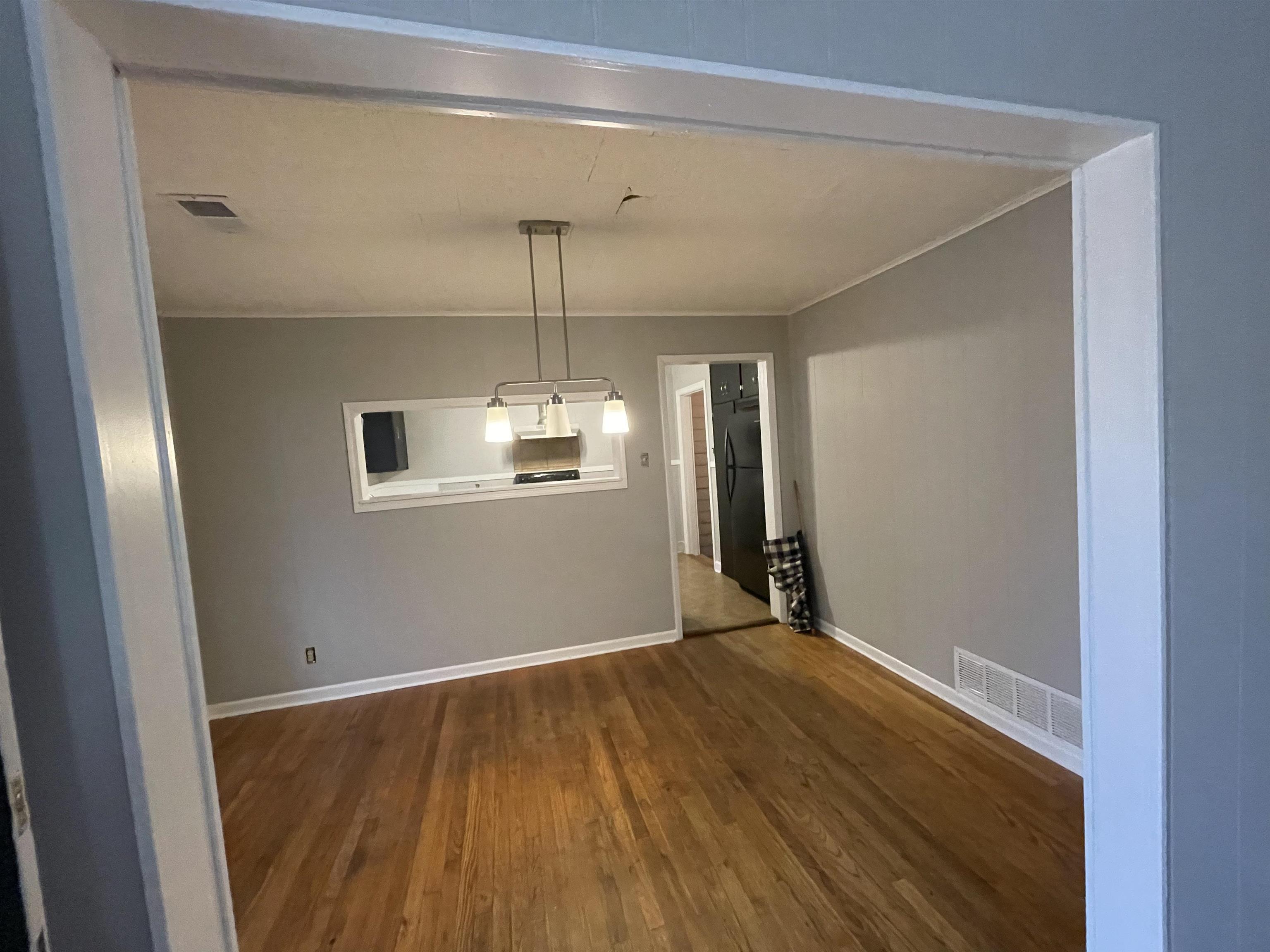 885 Echles Street Memphis, TN 38111 - Photo 7 of 18 a view of an empty room with wooden floor kitchen view and a window