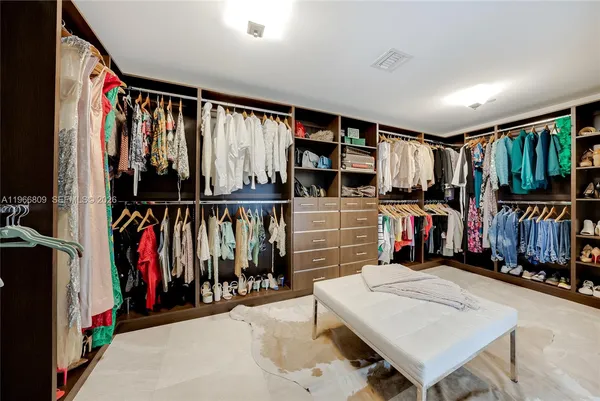 a view of walk in closet with clothes