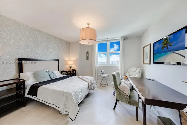 a bedroom with a bed and a chandelier