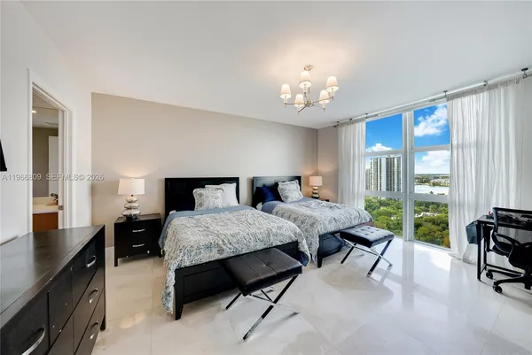 a spacious bedroom with a bed a table and large windows