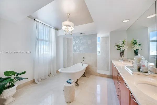 a spacious bathroom with a table and chandelier