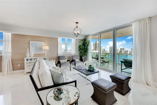 a living room with furniture and floor to ceiling windows