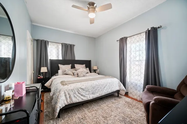 a bedroom with a bed a couch and a window