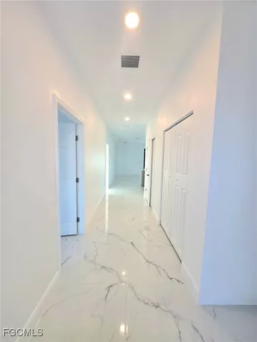 a large kitchen with stainless steel appliances a large counter top a refrigerator and a sink