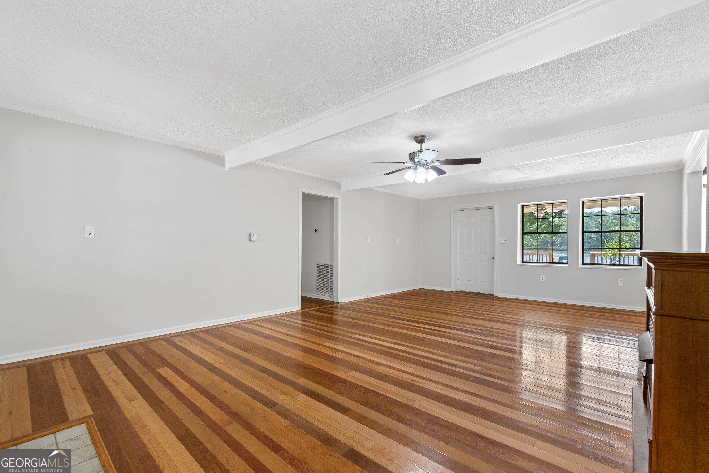 274 South Steel Bridge Road Eatonton, GA 31024 - Photo 3 of 39 a view of empty room with wooden floor and fan
