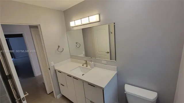 a bathroom with a sink a toilet and a mirror