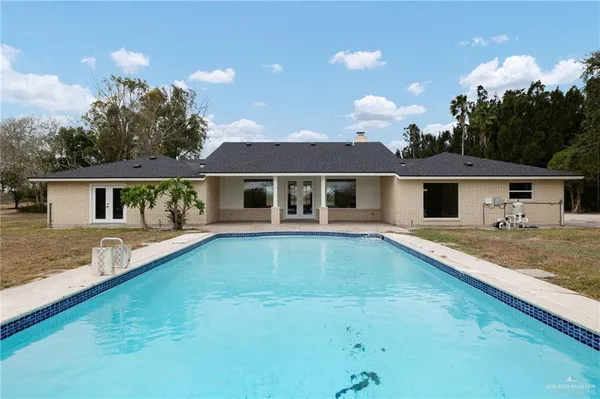 a view of a swimming pool with an outdoor seating and a yard