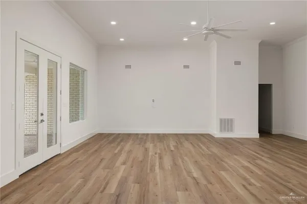 a view of an empty room with wooden floor