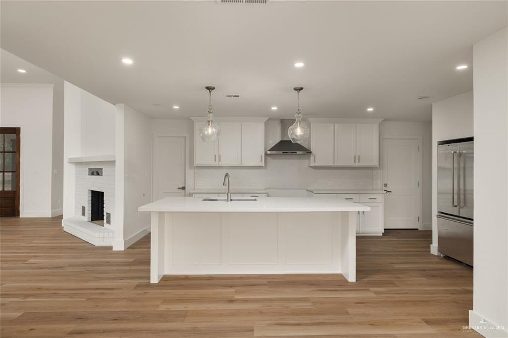 34732 Kretz Road, Unit 2 Los Fresnos, TX 78566 - Photo 22 of 22 a large kitchen with kitchen island a sink a stove a refrigerator and white cabinets with wooden floor