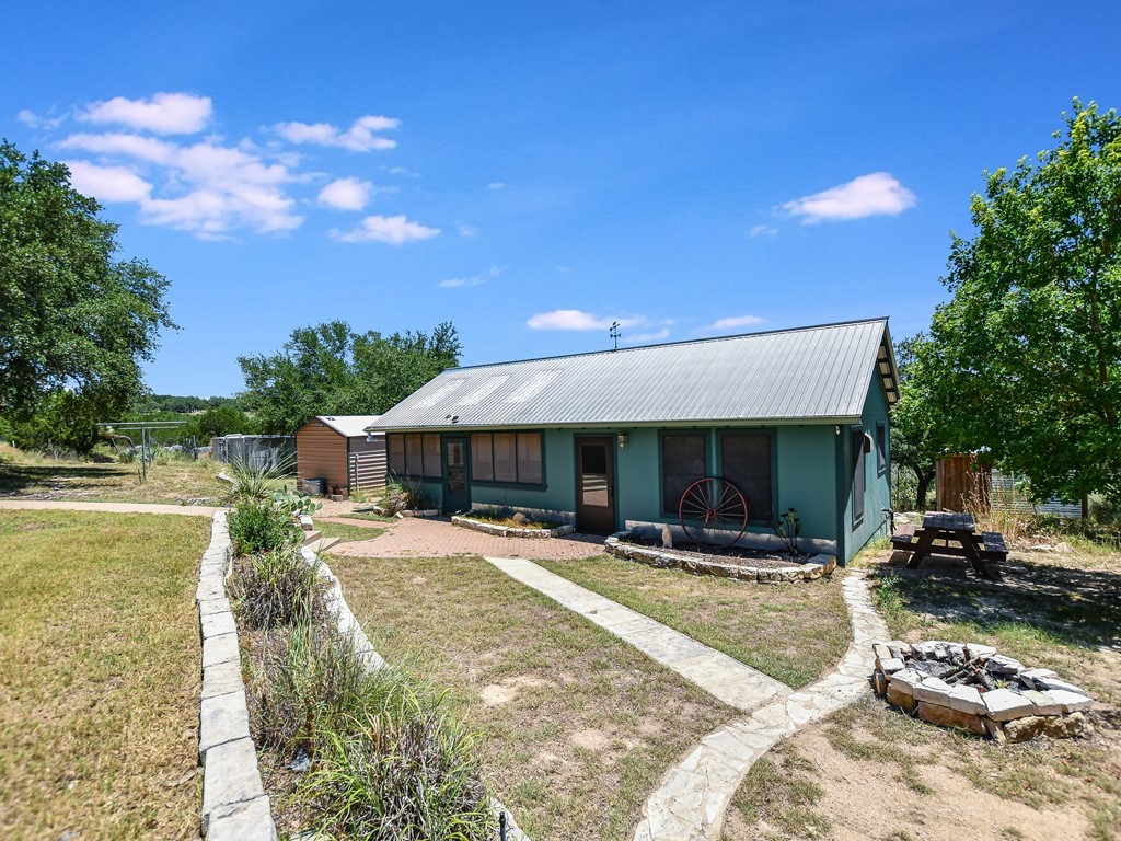 254 Middleton Road Spicewood, TX 78669 - Photo 30 of 32 a view of a patio with table and chairs with wooden floor and fence