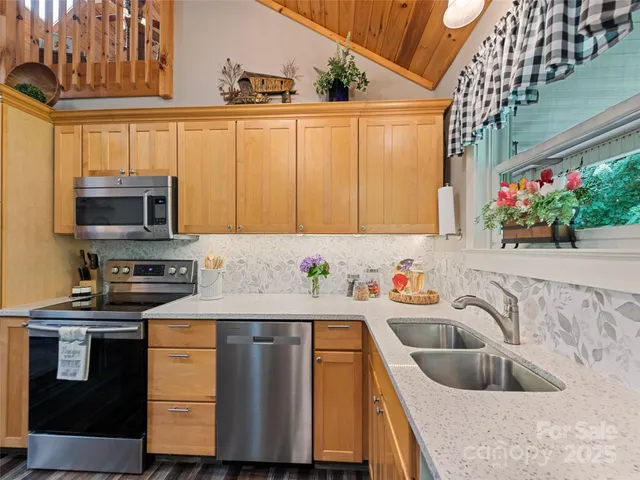 a kitchen with stainless steel appliances granite countertop a sink and a microwave