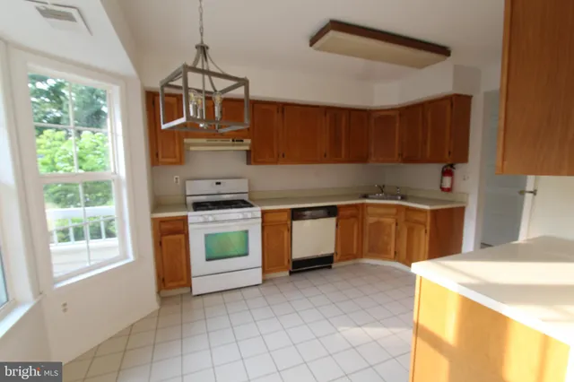 a kitchen with a stove a sink and a window