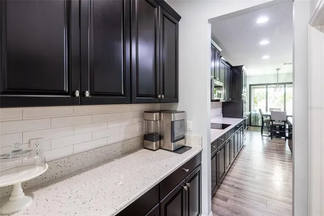 a kitchen with stainless steel appliances refrigerator dining table and chairs