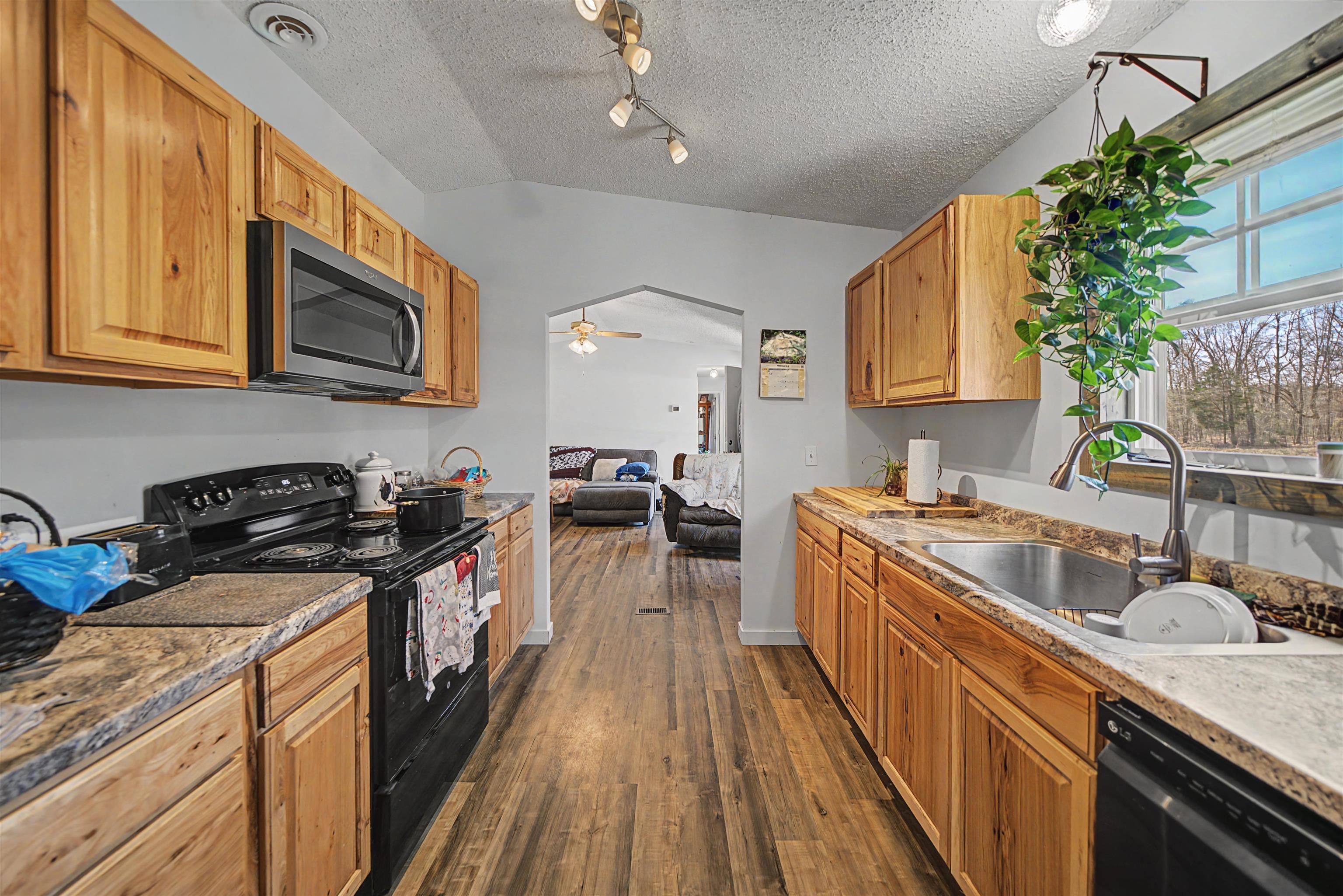 7010 22nd Highway Adamsville, TN 38310 - Photo 6 of 33 a kitchen with a stove a sink and a microwave