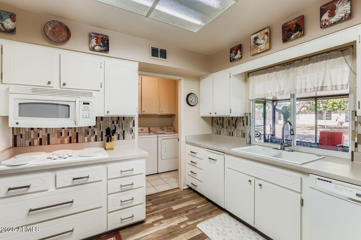 9524 West Greenway Road Sun City, AZ 85351 - Photo 16 of 25 a kitchen with granite countertop white cabinets white appliances and a sink