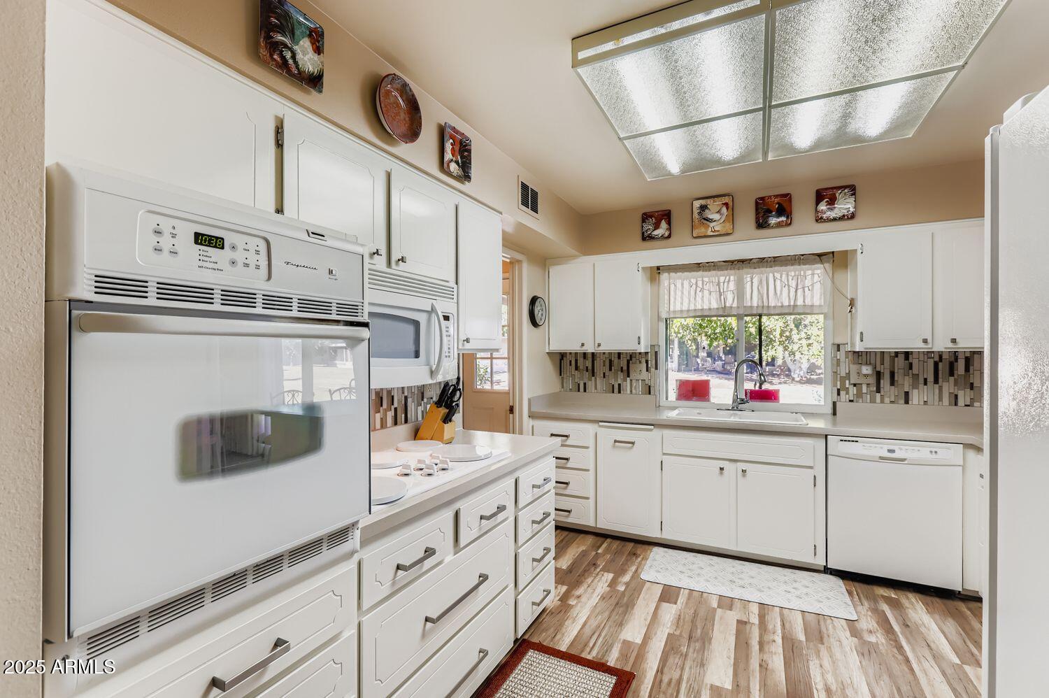 9524 West Greenway Road Sun City, AZ 85351 - Photo 17 of 25 a kitchen with stainless steel appliances granite countertop a sink and cabinets