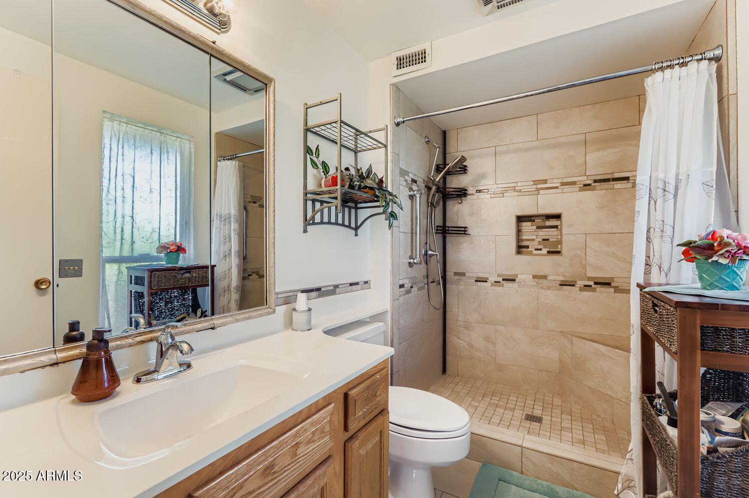 9524 West Greenway Road Sun City, AZ 85351 - Photo 19 of 25 a bathroom with a granite countertop sink a toilet and shower
