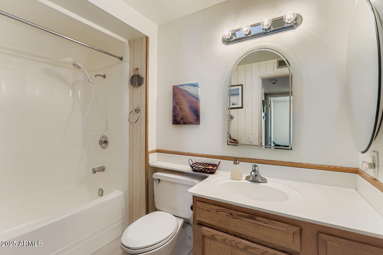 9524 West Greenway Road Sun City, AZ 85351 - Photo 21 of 25 a bathroom with a toilet sink and mirror