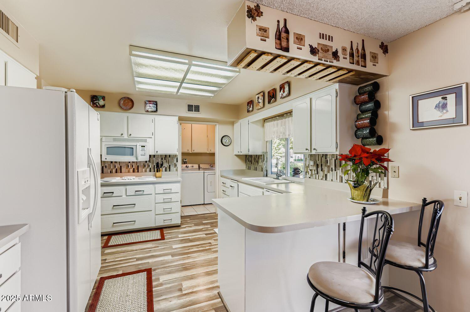 9524 West Greenway Road Sun City, AZ 85351 - Photo 6 of 25 a kitchen with stainless steel appliances kitchen island granite countertop a refrigerator and microwave