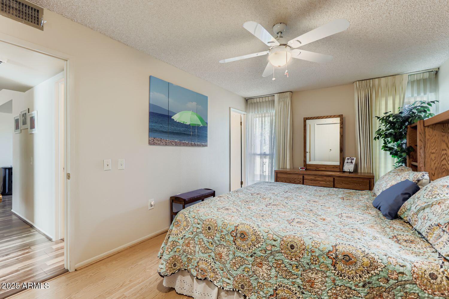 9524 West Greenway Road Sun City, AZ 85351 - Photo 8 of 25 a bedroom with a large bed and a chandelier