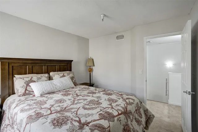 a bedroom with a bed and a lamp on dresser