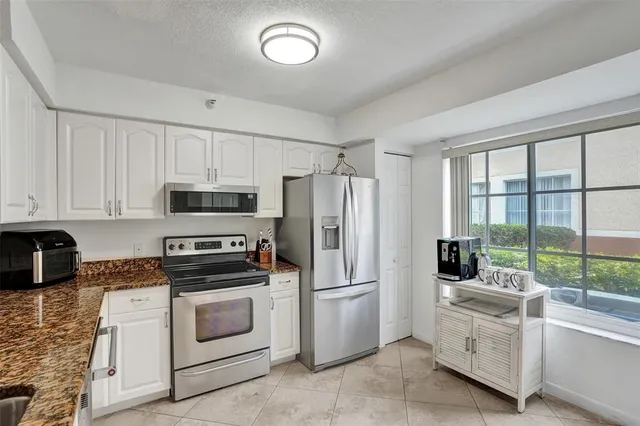 a kitchen with white cabinets and white appliances