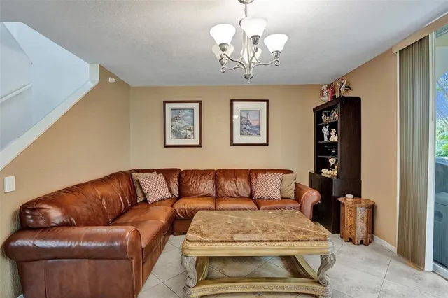 a living room with furniture a flat screen tv and kitchen view