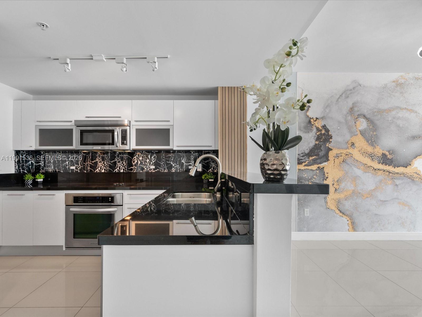 244 Biscayne Boulevard, Unit 1605 Miami, FL 33132 - Photo 2 of 46 a kitchen with a sink and a stove top oven
