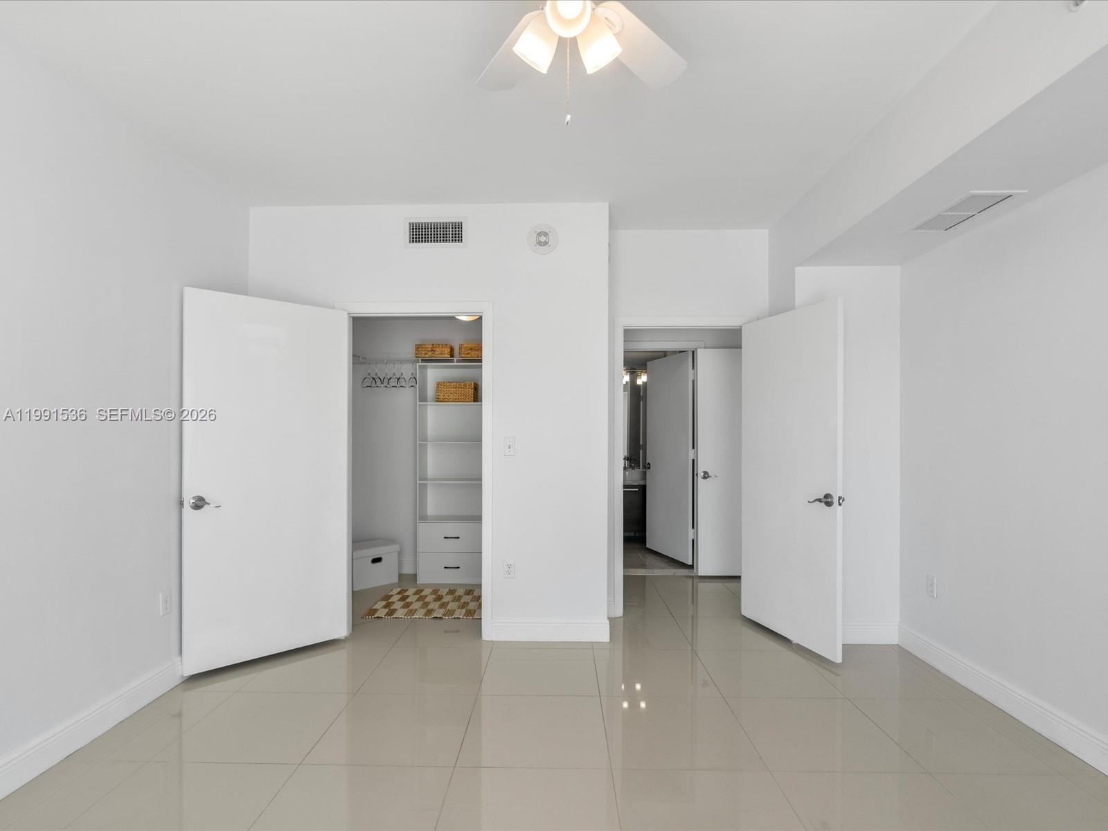 244 Biscayne Boulevard, Unit 1605 Miami, FL 33132 - Photo 24 of 46 an empty room with closet and a chandelier fan