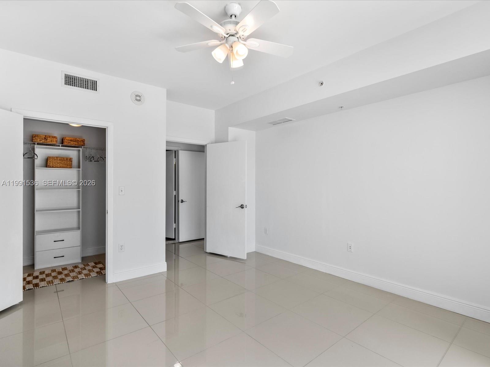 244 Biscayne Boulevard, Unit 1605 Miami, FL 33132 - Photo 25 of 46 an empty room with closet and fan
