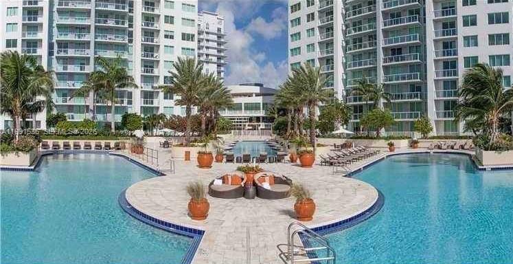 244 Biscayne Boulevard, Unit 1605 Miami, FL 33132 - Photo 33 of 46 a swimming pool with outdoor seating and water view