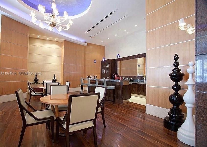 244 Biscayne Boulevard, Unit 1605 Miami, FL 33132 - Photo 42 of 46 a dining room with furniture a potted plant and wooden floor