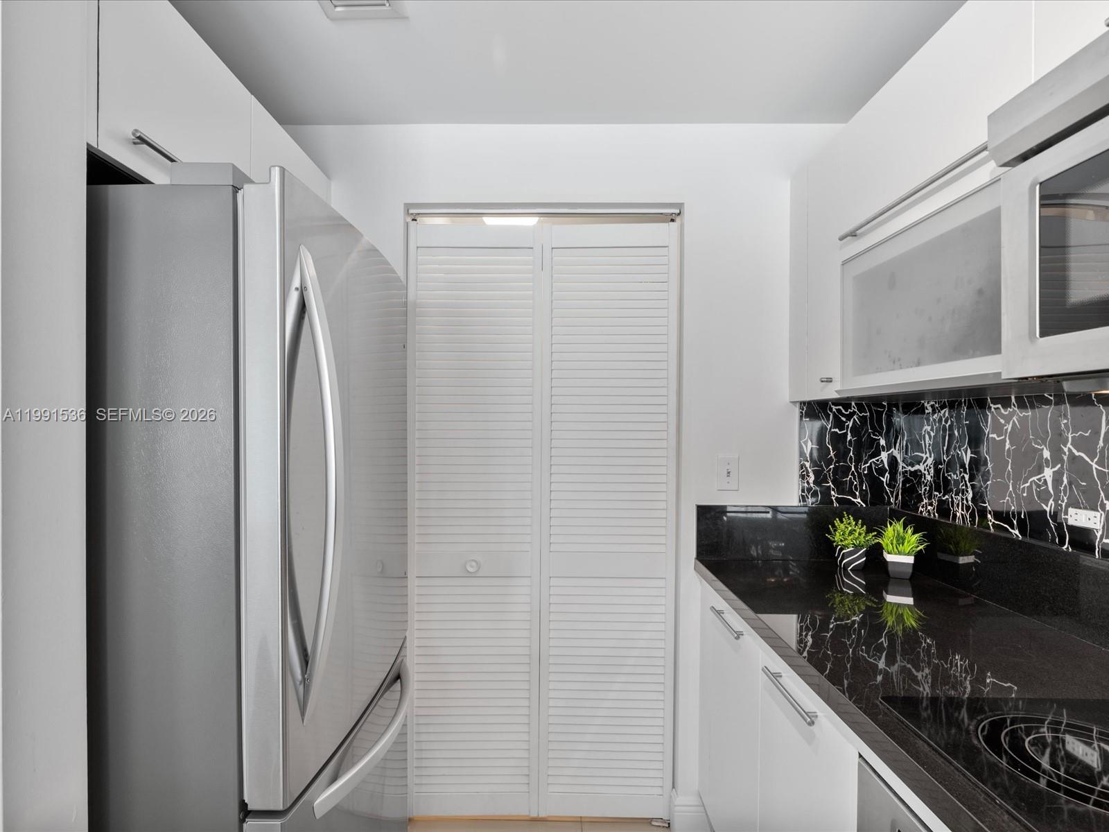 244 Biscayne Boulevard, Unit 1605 Miami, FL 33132 - Photo 6 of 46 a kitchen with stainless steel appliances granite countertop a refrigerator and a counter space