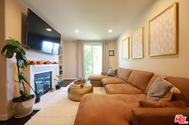 a living room with furniture a fireplace and a flat screen tv