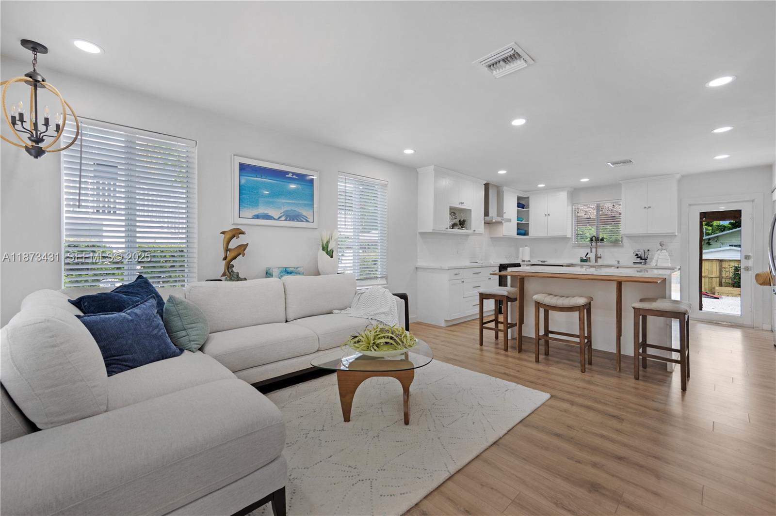 53 Bonefish Avenue Key Largo, FL 33037 - Photo 19 of 25 a living room kitchen with a couch and a dining table with wooden floor