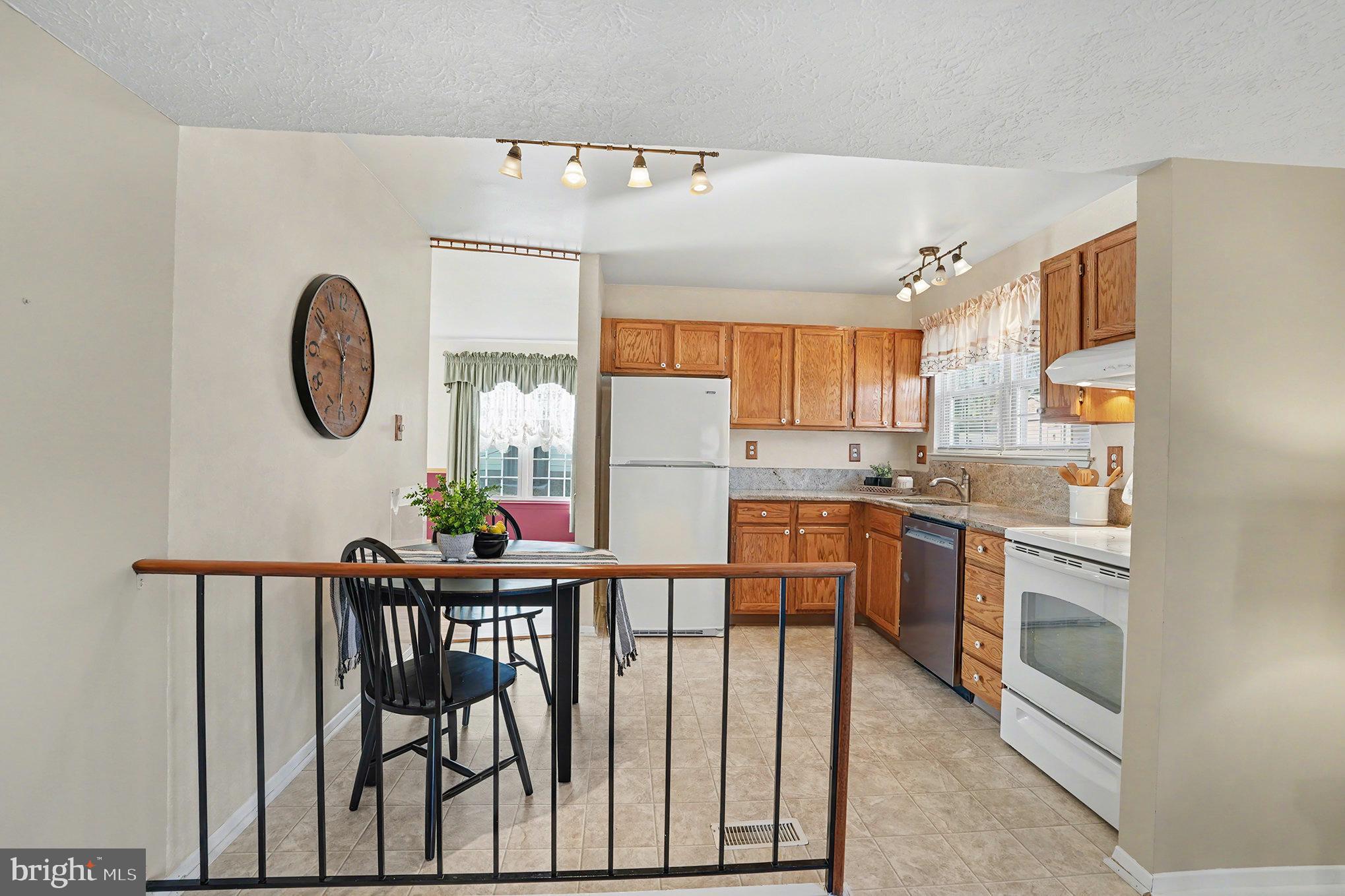 7114 Oliver Beach Road Baltimore, MD 21220 - Photo 13 of 49 a kitchen with stainless steel appliances granite countertop a stove a refrigerator a microwave oven with a dining table and chairs