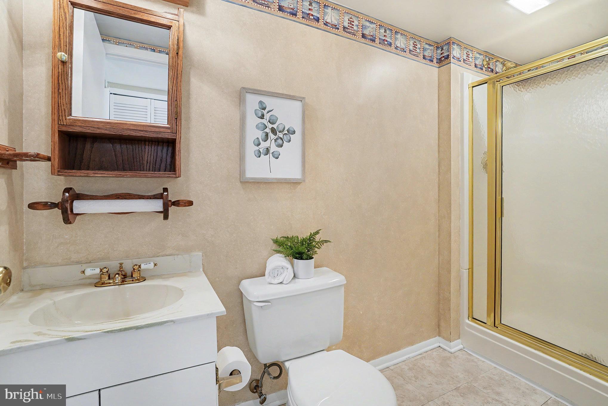 7114 Oliver Beach Road Baltimore, MD 21220 - Photo 15 of 49 a bathroom with a sink mirror vanity and toilet