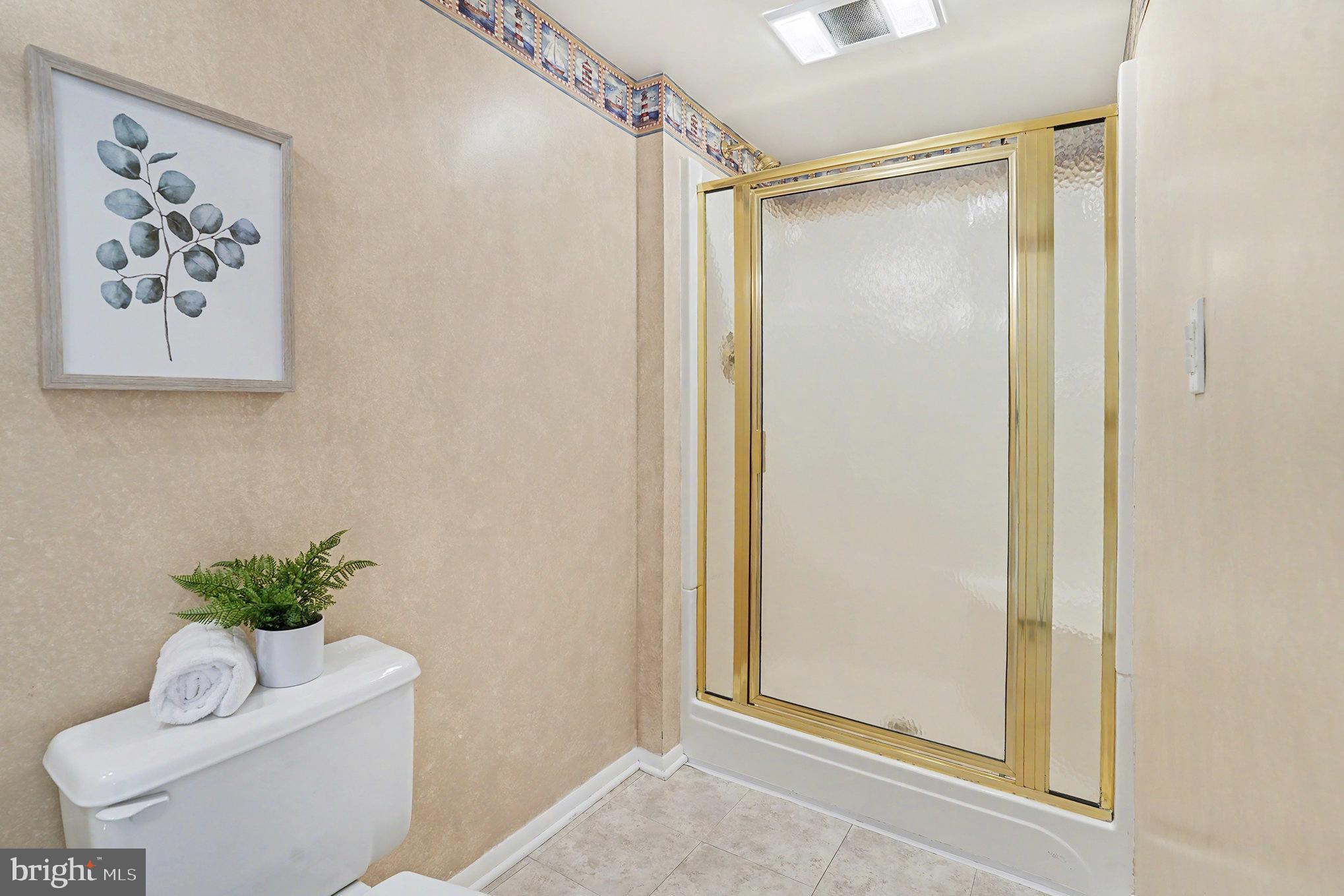 7114 Oliver Beach Road Baltimore, MD 21220 - Photo 16 of 49 a bathroom with a shower curtain and a toilet