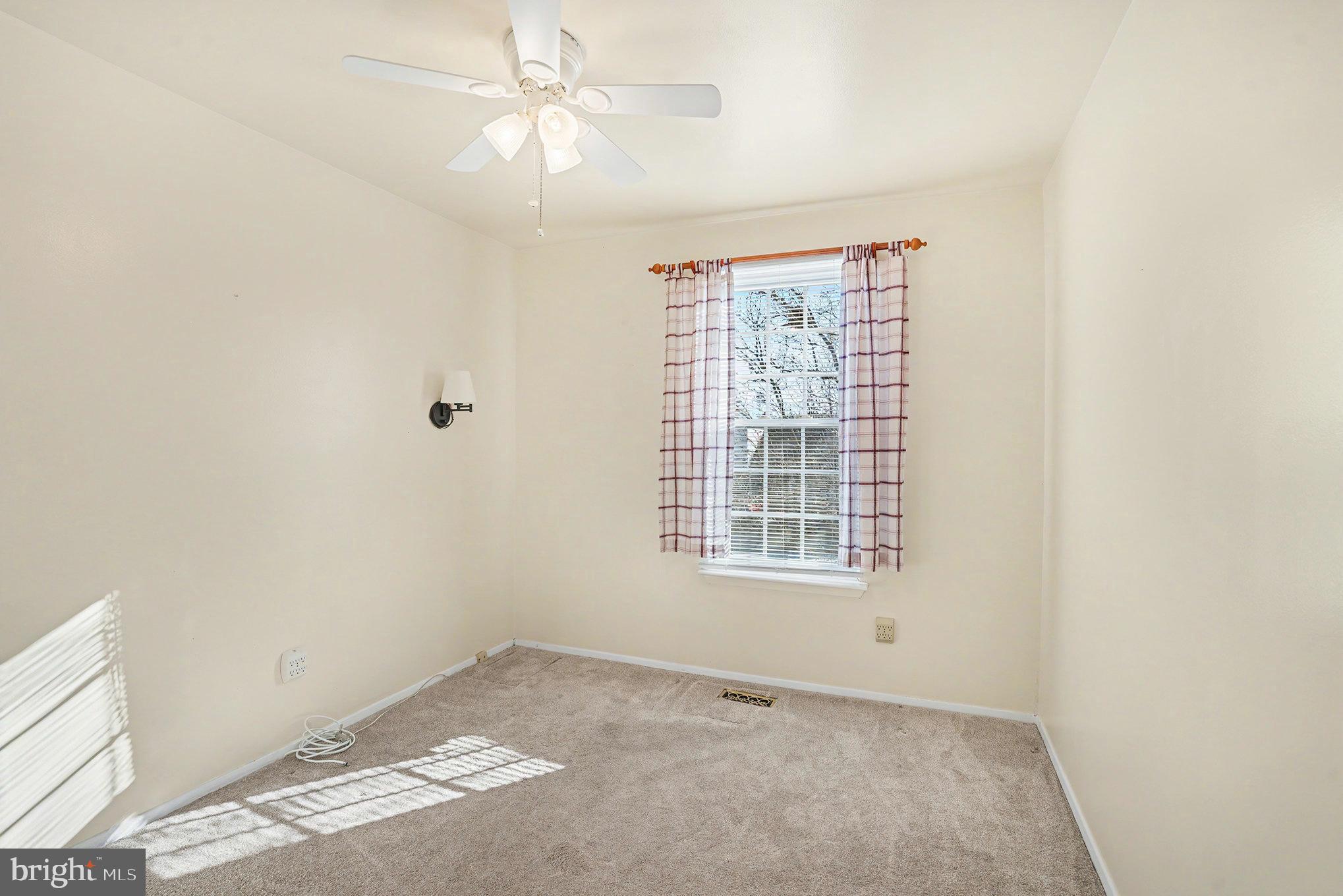 7114 Oliver Beach Road Baltimore, MD 21220 - Photo 25 of 49 an empty room with a window and ceiling fan