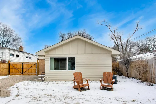 a backyard of a house with lawn chairs and wooden fence