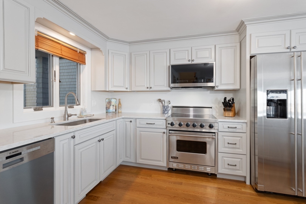 13 Rowe Point, Unit 13 Rockport, MA 01966 - Photo 3 of 27 a kitchen with white cabinets and stainless steel appliances