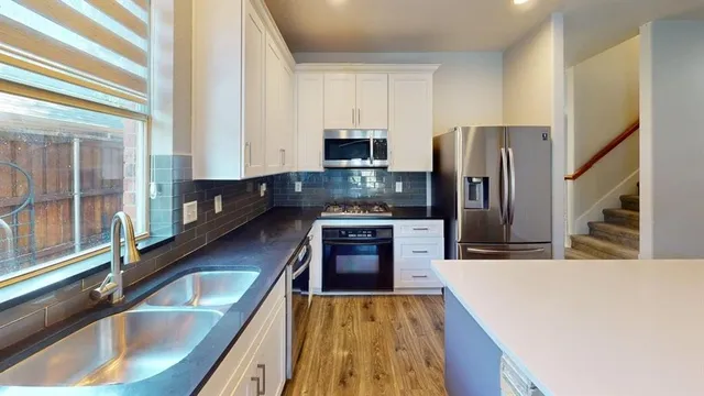 a kitchen with stainless steel appliances granite countertop a sink stove and refrigerator