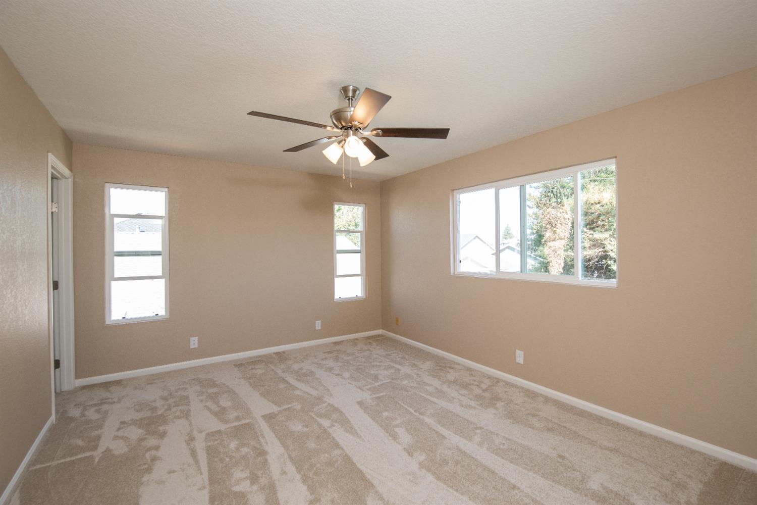 1621 Davis Street Ripon, CA 95366 - Photo 31 of 43 unfurnished room with healthy amount of natural light, ceiling fan, and light carpet