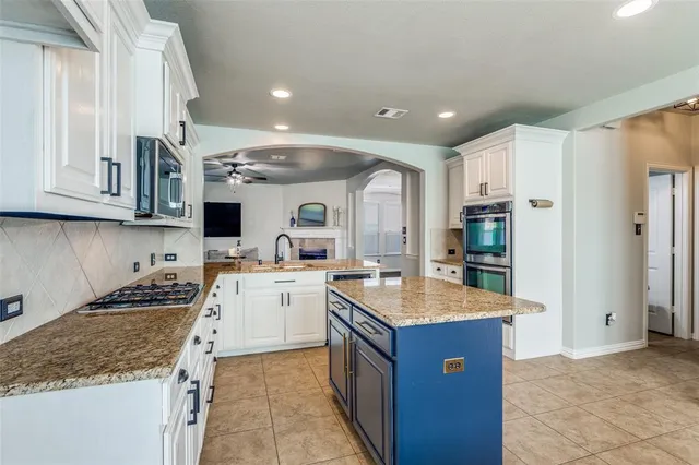 a kitchen with a sink stove top oven and refrigerator
